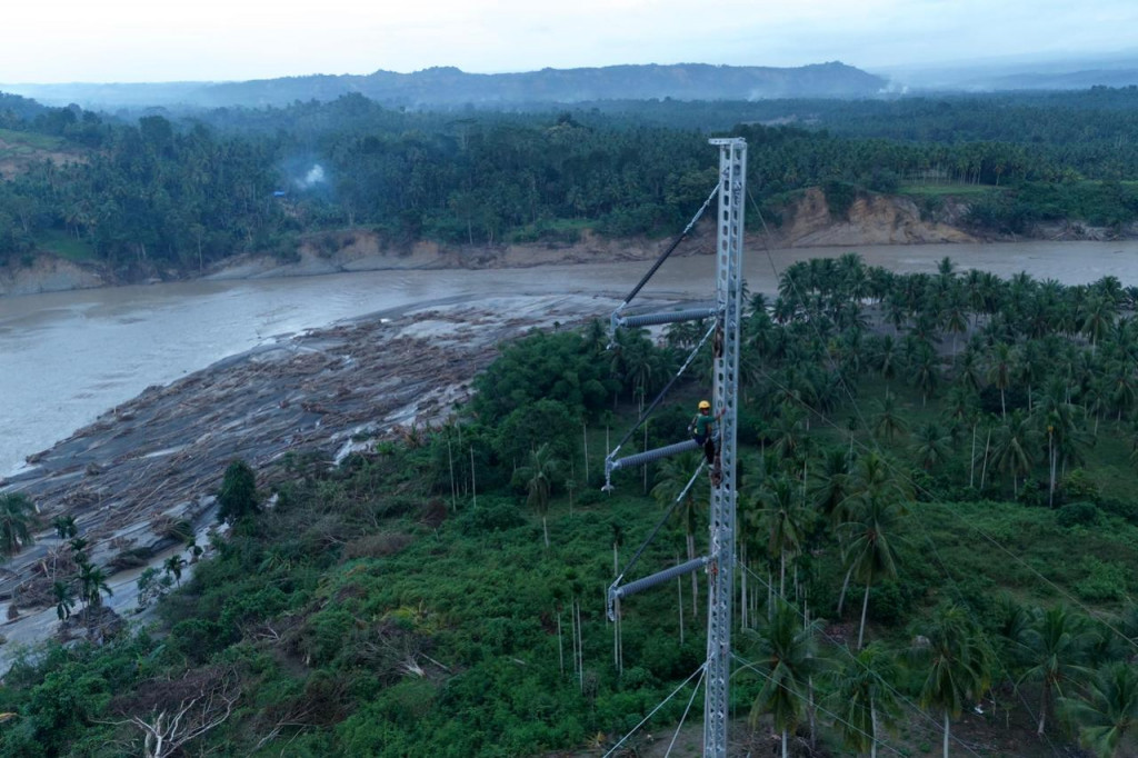 Petugas PLN ketika melakukan penyambungan kabel transmisi Saluran Udara Tegangan Tinggi (SUTT) 150 kilovolt (kV) Arun - Bireuen di atas emergency tower yang telah didirikan.