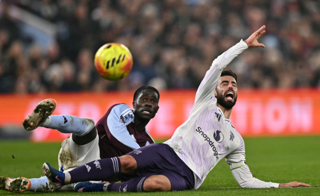 Gelandang Manchester United, Bruno Fernandes, meringis setelah ditekel gelandang Aston Villa, Amadou Onana (AFP/Ben Stansall)