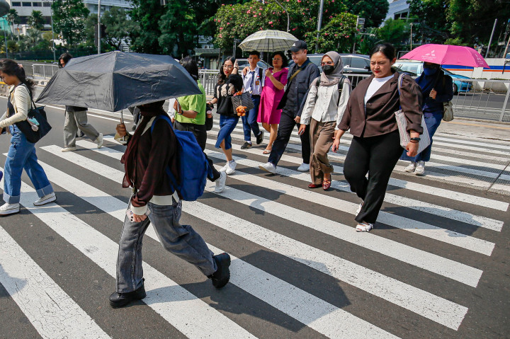 ​Cuaca Panas Jakarta Capai 36 Derajat, Warga Gunakan Payung