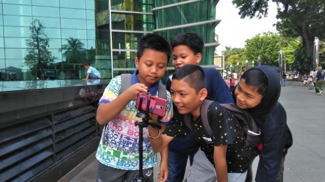 Anak-anak tengah mengamati gerhana matahari. Foto: Medcom/Muhammad Syahrul