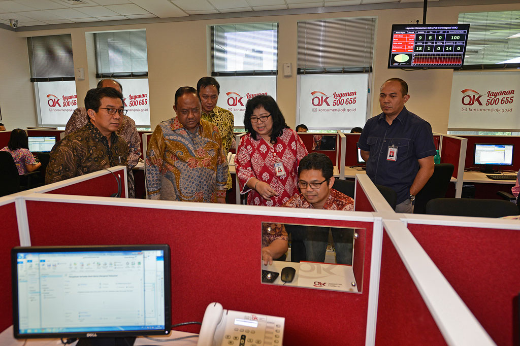 Ketua Dewan Komisioner Otoritas Jasa Keuangan (OJK) Muliaman Hadad (kiri) dan Kepala Badan Intelijen Negara (BIN) Marciano Norman (kedua kiri) mendengar penjelasan Direktur Pelayanan Konsumen OJK Sondang Martha (tengah) di ruang Pusat Pelayanan Konsumen Keuangan Terintegrasi OJK, usai penandatanganan MoU antara kedua pihak di komplek gedung Bank Indonesia, Jakarta Pusat, Jumat (21/3).