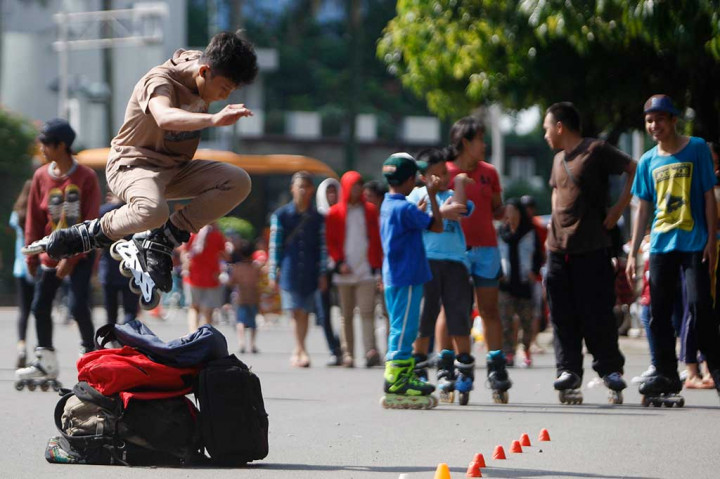 Puluhan remaja melakukan atraksi free style sepatu roda ketika pelaksanaan Hari Bebas Kendaraan Bermotor di Bundaran HI, Jakarta Pusat, Minggu (13/4).
