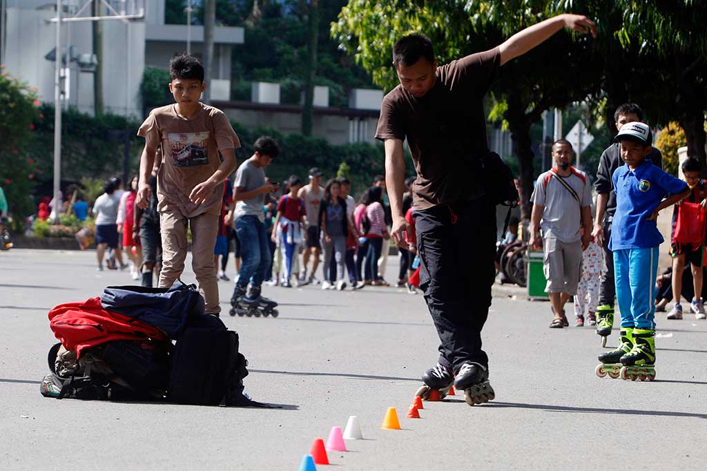 Puluhan remaja melakukan atraksi free style sepatu roda ketika pelaksanaan Hari Bebas Kendaraan Bermotor di Bundaran HI, Jakarta Pusat, Minggu (13/4).