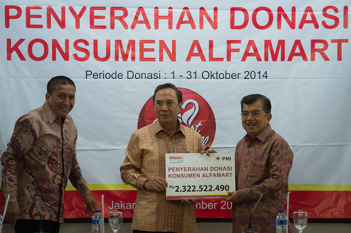 Wapres Jusuf Kalla selaku Ketua Umum PMI menerima penyerahan donasi konsumen Alfamart dari founder Alfamart Djoko Susanto dan Corporate Affairs Director Alfamart Solihin di Kantor PMI, Jalan Gatot Subroto, Jakarta, Jumat (12/12).