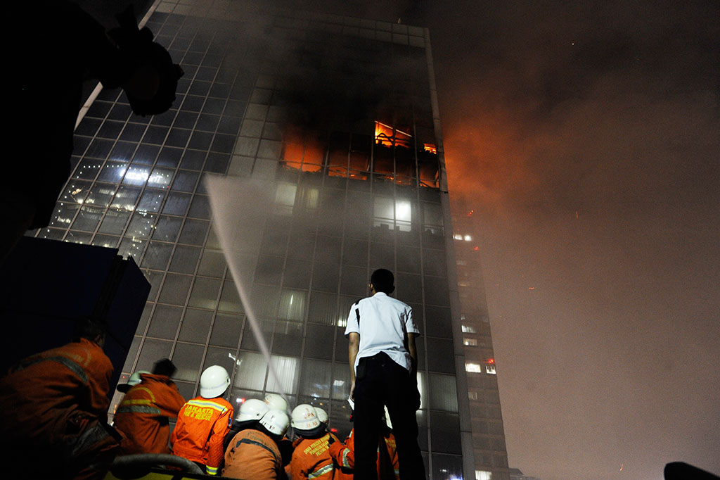 Petugas pemadam kebakaran berusaha memadamkan api yang membakar Gedung Wisma Kosgoro di Jalan MH Thamrin, Jakarta Pusat, Senin (9/3).