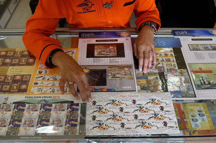 Petugas menunjukkan dua prangko seri Shio Tahun Kambing dan alat musik tradisional yang diterbitkan oleh PT Pos Indonesia di Jakarta, Selasa (10/3).