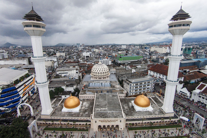 Warga bermain di Alun-alun Kota Bandung, Jawa Barat, Sabtu (25/4). Kawasan seluas 4.000 meter persegi yang menyuguhkan hamparan rumput sintetis tersebut terletak di depan Masjid Raya Bandung dan menjadi destinasi wisata alternatif yang ramai dikunjungi masyarakat pada akhir pekan. 