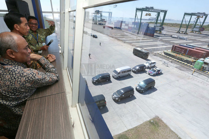 Presiden Joko Widodo (tengah) bersama Dirut Pelindo III Jarwo Suryanto (kiri) mendengarkan penjelasan Direktur Operasional dan Tekhnik Terminal Teluk Lamong Agung Kresno Sarwono saat meninjau akivitas bongkar muat peti kemas di Terminal Teluk Lamong