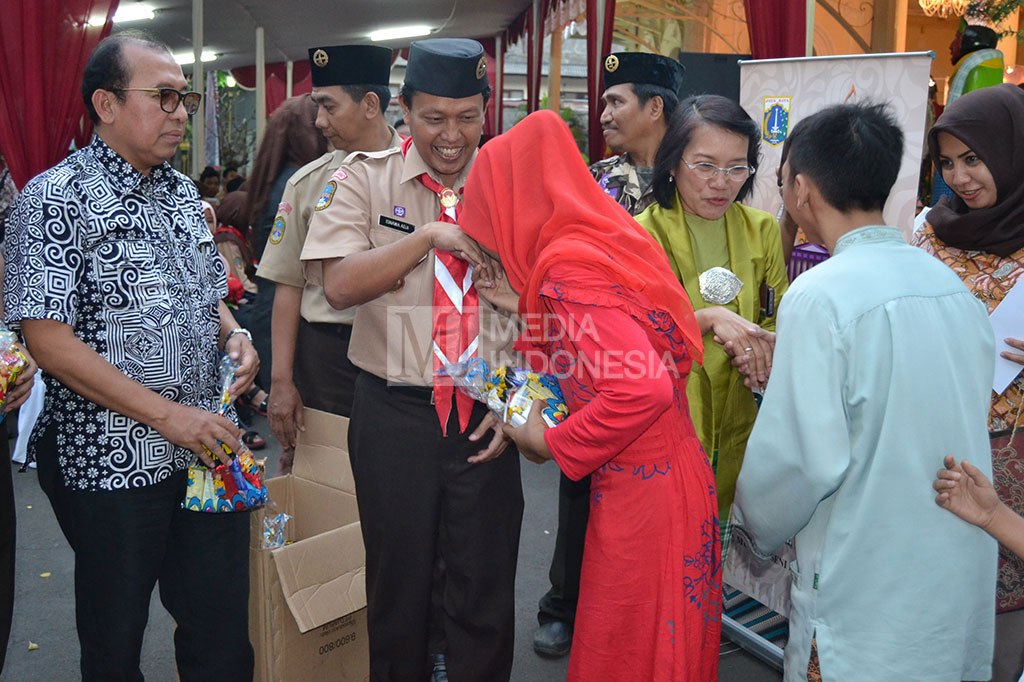 Kepala UP Museum Tekstil Dyah Damayanti didampingi Ketua Kwarcab Jakarta Barat memberikan santunan kepada ratusan anak yatim-piatu pada pembukaan Enjoy Ramadhan.