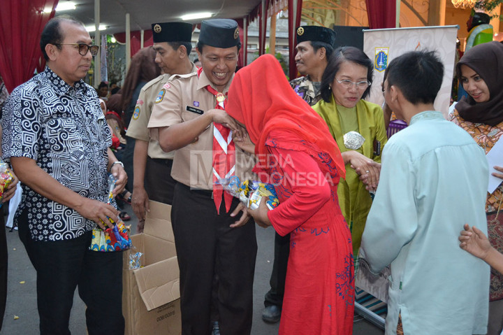 Kepala UP Museum Tekstil Dyah Damayanti didampingi Ketua Kwarcab Jakarta Barat memberikan santunan kepada ratusan anak yatim-piatu pada pembukaan Enjoy Ramadhan.