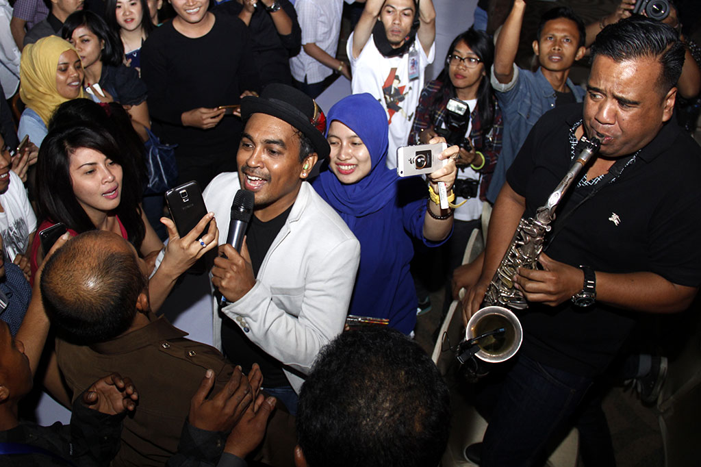 Penyanyi Glenn Fredly bernyanyi sambil mendatangi penggemarnya saat konser '20 tahun berkarya untuk Indonesia'