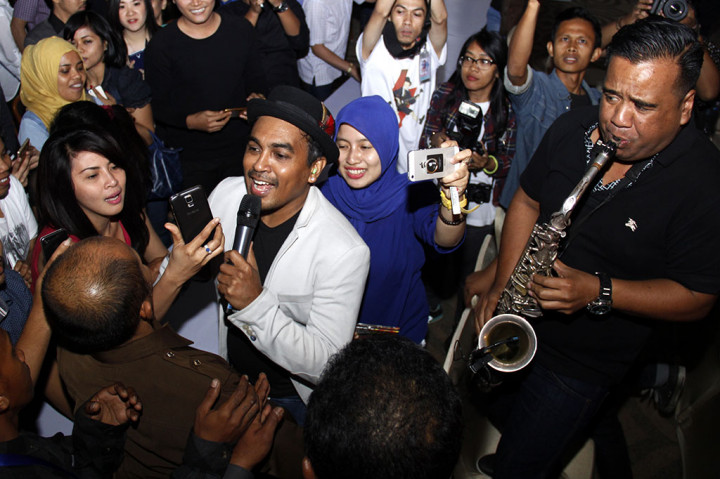 Penyanyi Glenn Fredly bernyanyi sambil mendatangi penggemarnya saat konser '20 tahun berkarya untuk Indonesia'