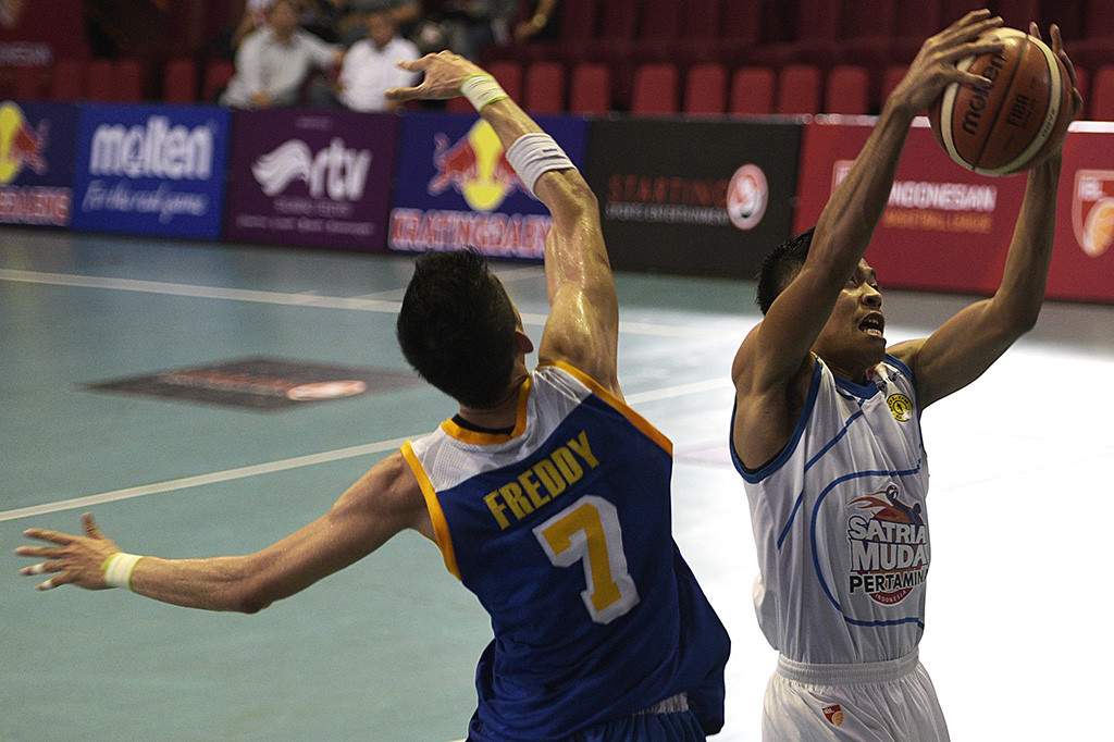 Pebasket Satria Muda Pertamina Jakarta Sitepu Christian (kiri) berebut bola rebound dengan dua pebasket Bimasakti Nikko Steel Malang Dwi Purnomo Restu (kedua kiri) dan Rachmad Danu (ketiga kiri) dalam pertandingan Indonesian Basketball League (IBL) 2015-2016 di Hall A Senayan