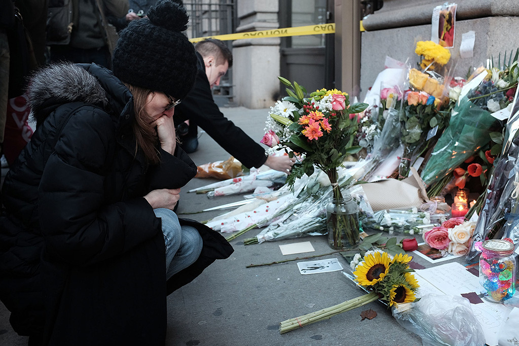 Masyarakat meletakkan karangan bunga di depan foto musisi dan pemain film David Bowie
