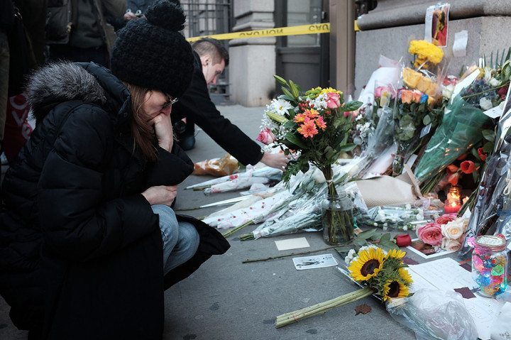 Masyarakat meletakkan karangan bunga di depan foto musisi dan pemain film David Bowie
