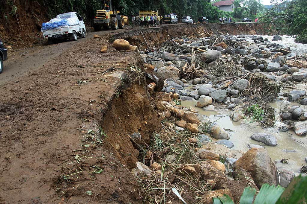 Puluhan kendaraan harus berhati-hati untuk melintasi jalan yang amblas