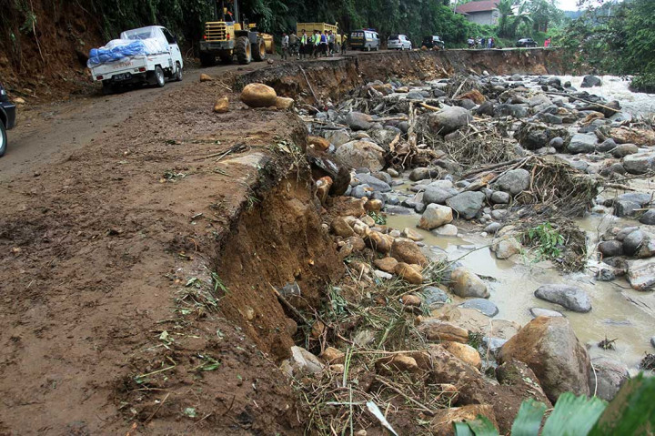 Puluhan kendaraan harus berhati-hati untuk melintasi jalan yang amblas