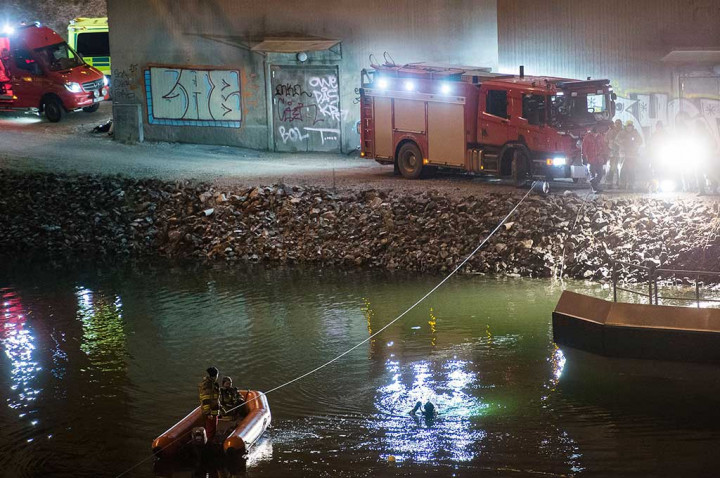 Penyelam dan regu penyelamat mencari korban kecelakaan mobil di kanal di bawah jembatan jalan raya E4 di Sodertalje, Swedia, 13 Februari 2016.