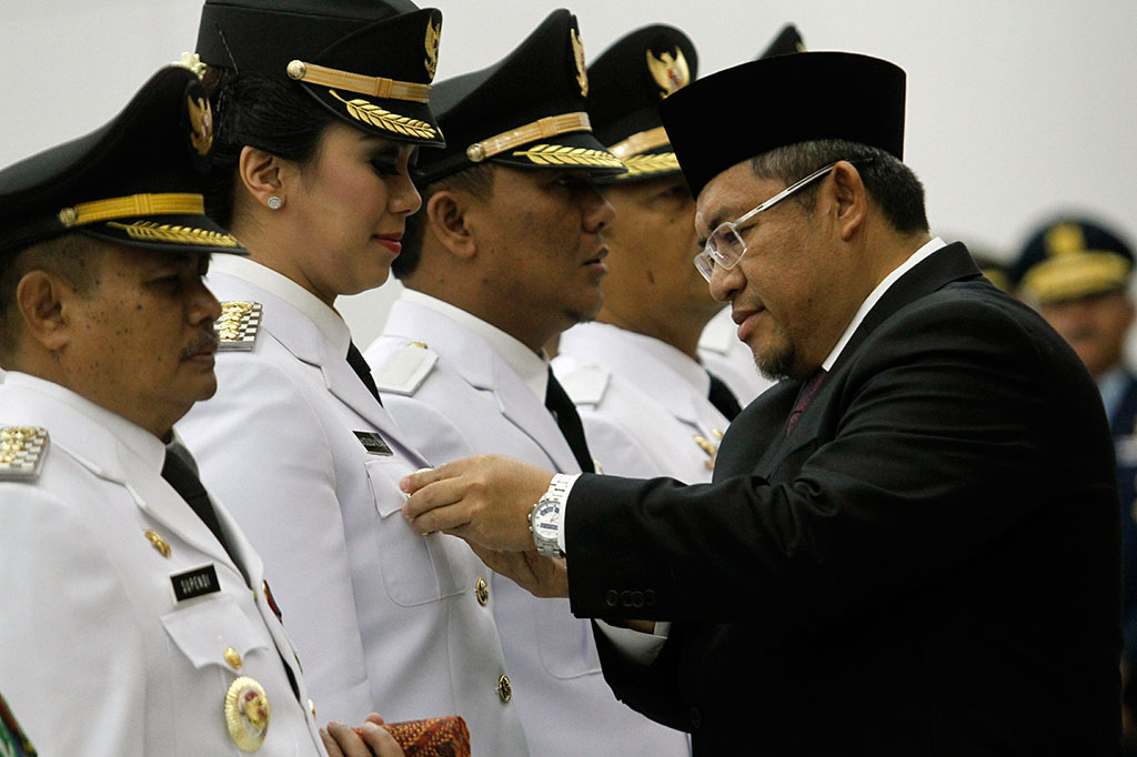 Gubernur Provinsi Jawa Barat, Ahmad Heryawan (kanan) menyematkan lencana jabatan kepada Bupati Karawang Cellica Nurrachdiana (kedua kiri) 