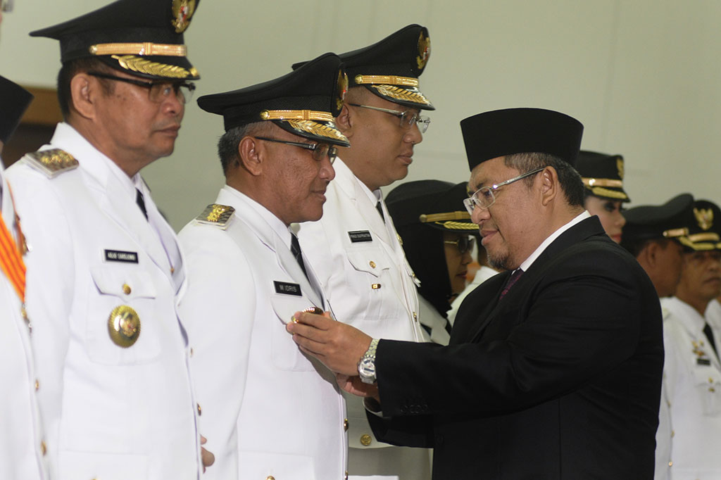 Ahmad Heryawan (kanan) menyematkan lencana jabatan kepada Wali Kota Depok, Idris Abdul Somad (kedua kiri) 