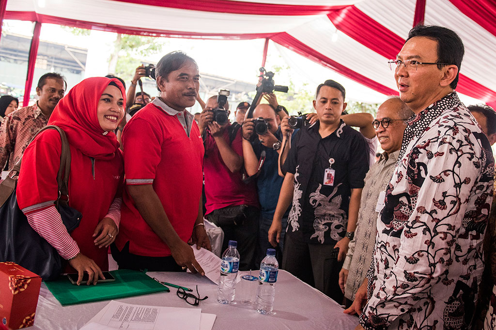 Basuki Tjahaja Purnama (kanan) didampingi Direktur Utama Bank DKI Kresno Sediarsi (kedua kanan) berbincang dengan pedagang disela penandatanganan penyaluran kredit kepada pedagang 