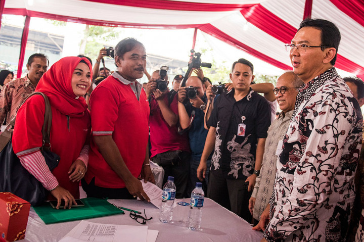 Basuki Tjahaja Purnama (kanan) didampingi Direktur Utama Bank DKI Kresno Sediarsi (kedua kanan) berbincang dengan pedagang disela penandatanganan penyaluran kredit kepada pedagang 