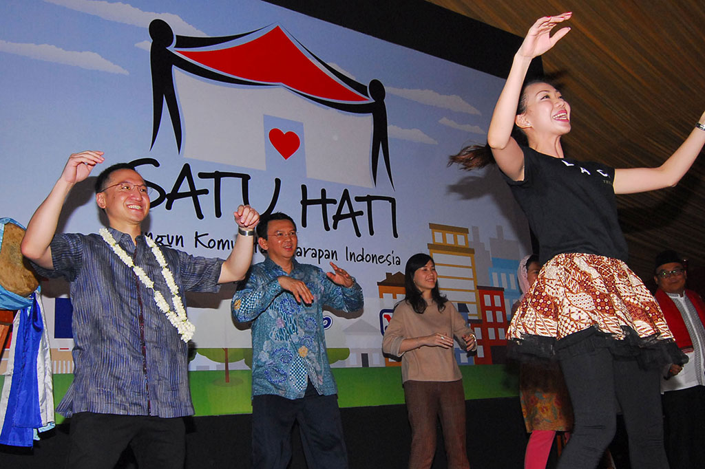 Basuki Tjahaja Purnama (kedua krii) bersama Ketua Yayasan Gerakan Kepedulian Indonesia (GK Indonesia) Arif Rachmat (kiri) berjoget saat peresmian kegiatan 'Gerakan Satu Hati Bangun Komunitas Harapan Indonesia'