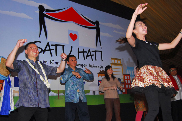 Basuki Tjahaja Purnama (kedua krii) bersama Ketua Yayasan Gerakan Kepedulian Indonesia (GK Indonesia) Arif Rachmat (kiri) berjoget saat peresmian kegiatan 'Gerakan Satu Hati Bangun Komunitas Harapan Indonesia'
