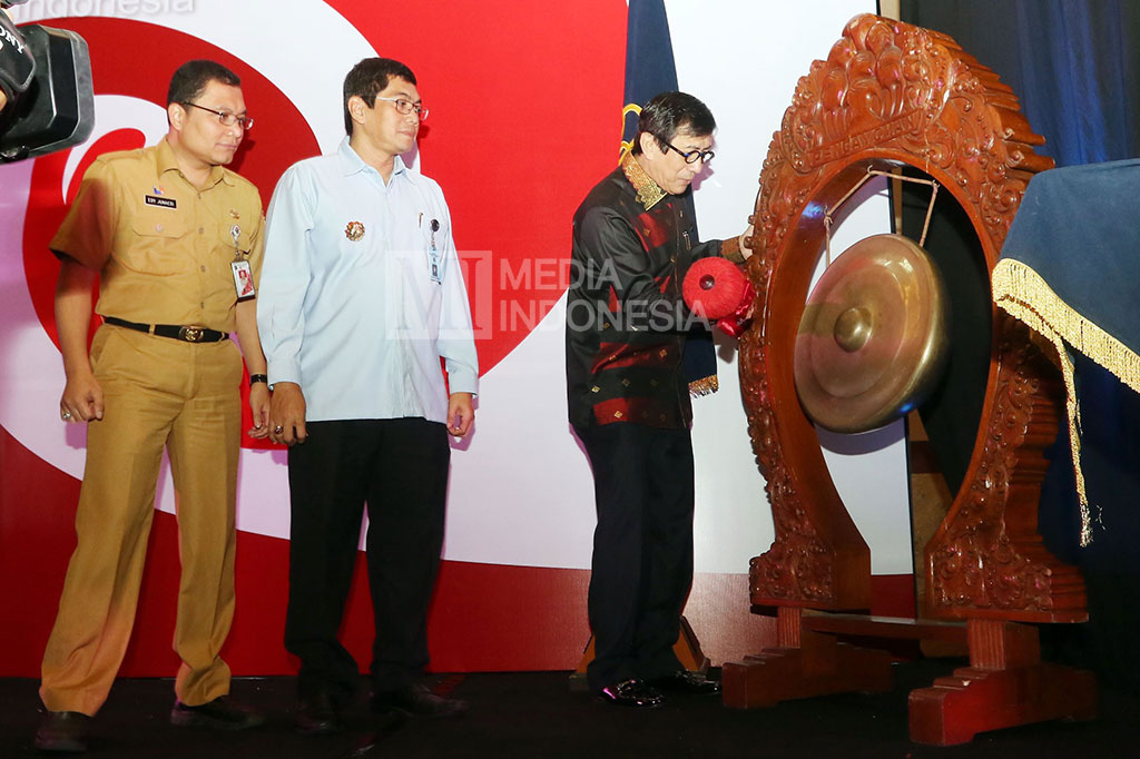 Menteri Hukum dan HAM Yasonna H. Laoly (kanan) bersama Direktur Jenderal Administrasi Hukum pada Kementerian Hukum dan HAM Umum Freddy Harris (kedua kiri) dan Ketua PTSP DKI Jakarta Edi Junedi, memukul gong 