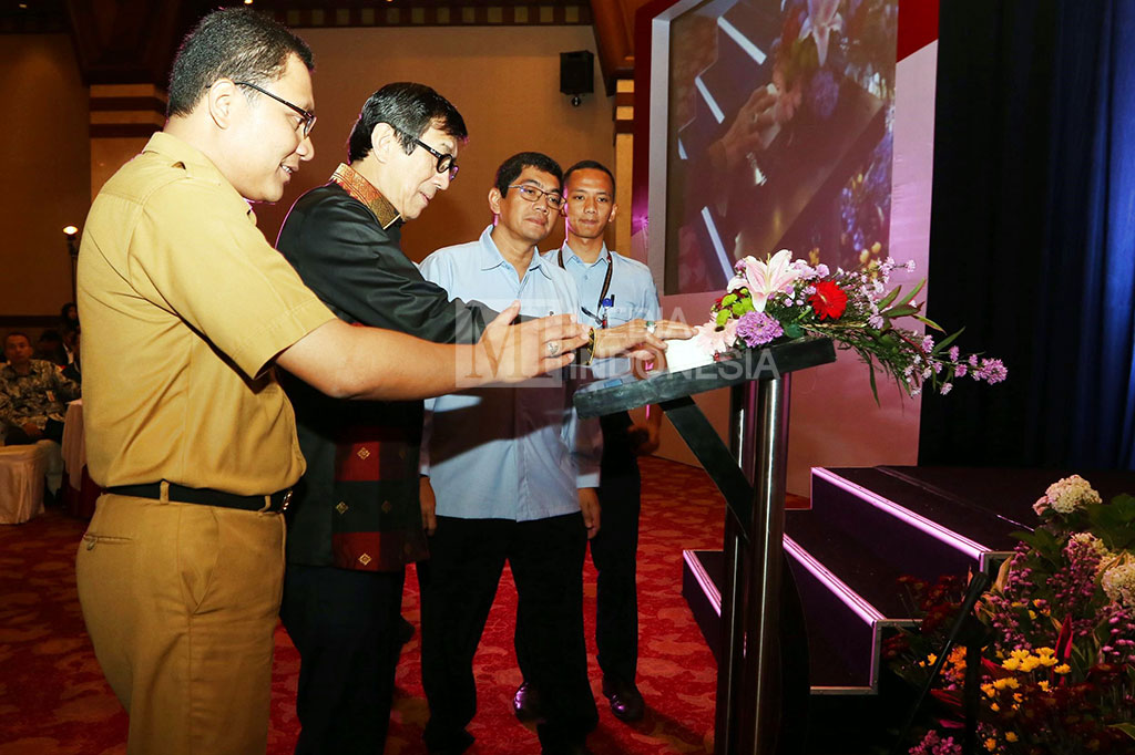 Yasonna H. Laoly (kedua kiri) bersama Direktur Jenderal Administrasi Hukum pada Kementerian Hukum dan HAM Umum Freddy Harris (kedua kanan) dan Ketua PTSP DKI Jakarta Edi Junedi (kiri) menekan tombol sebagai simbol launching program Kementerian Hukum dan HAM 
