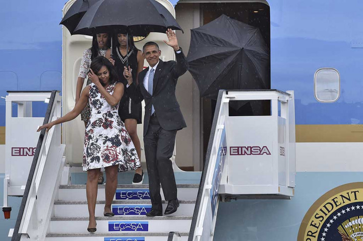 Di bawah guyuran hujan Obama bersama istri dan kedua putrinya menuruni pesawat Air Forde One di Bandara Internasional Jose Marti di Havana.