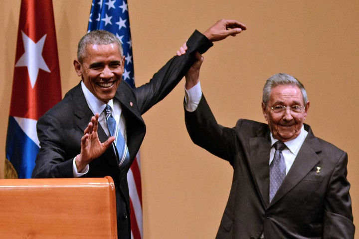 Raul Castro mengangkat tangan Obama usai melakukan konferensi pers.