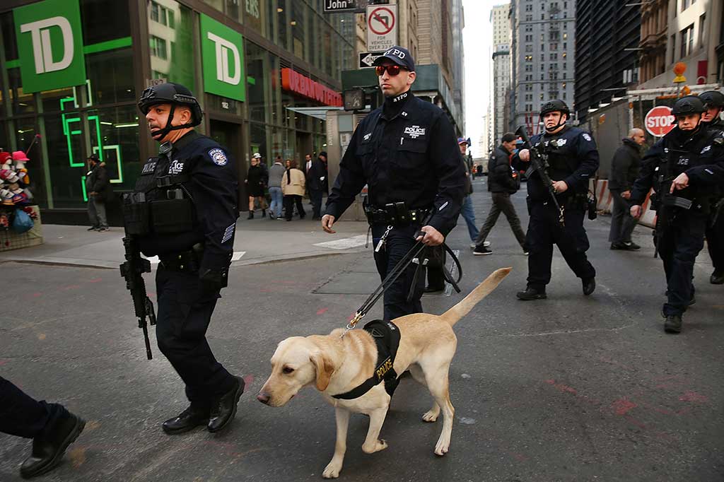 Polisi bersenjata lengkap berpatroli di jalan-jalan di Manhattan menyusul serangan di Brussels, Belgia.