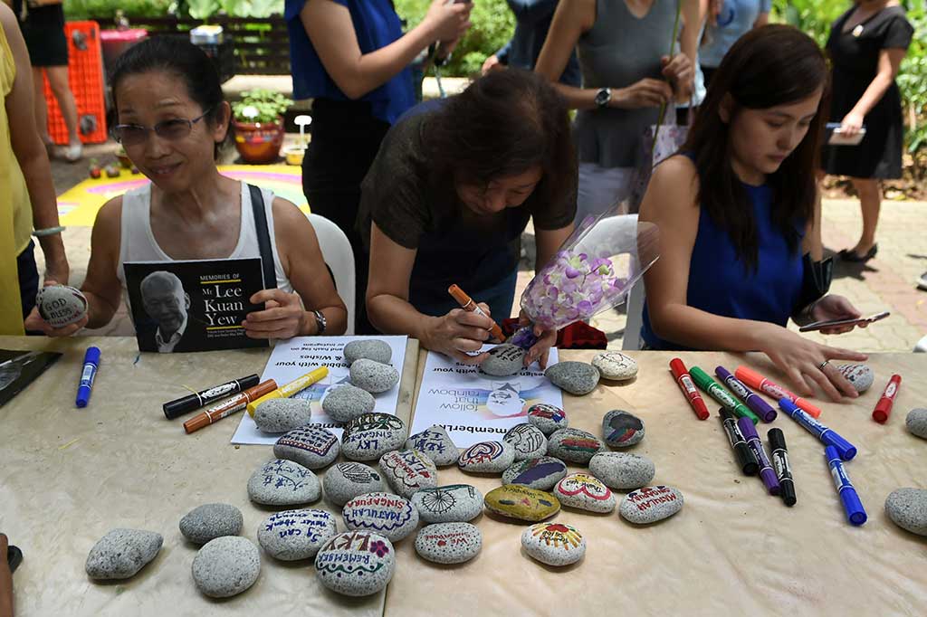 Warga menulis pesan dan doa di batu-batu kecil untuk bapak pendiri Singapura Lee Kuan Yew.