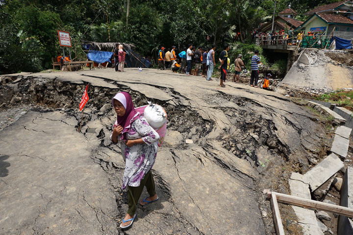 Warga melintasi lokasi longsor di Desa Clapar, Madukara, Banjarnegara, Jateng, Sabtu (26/3/2016).