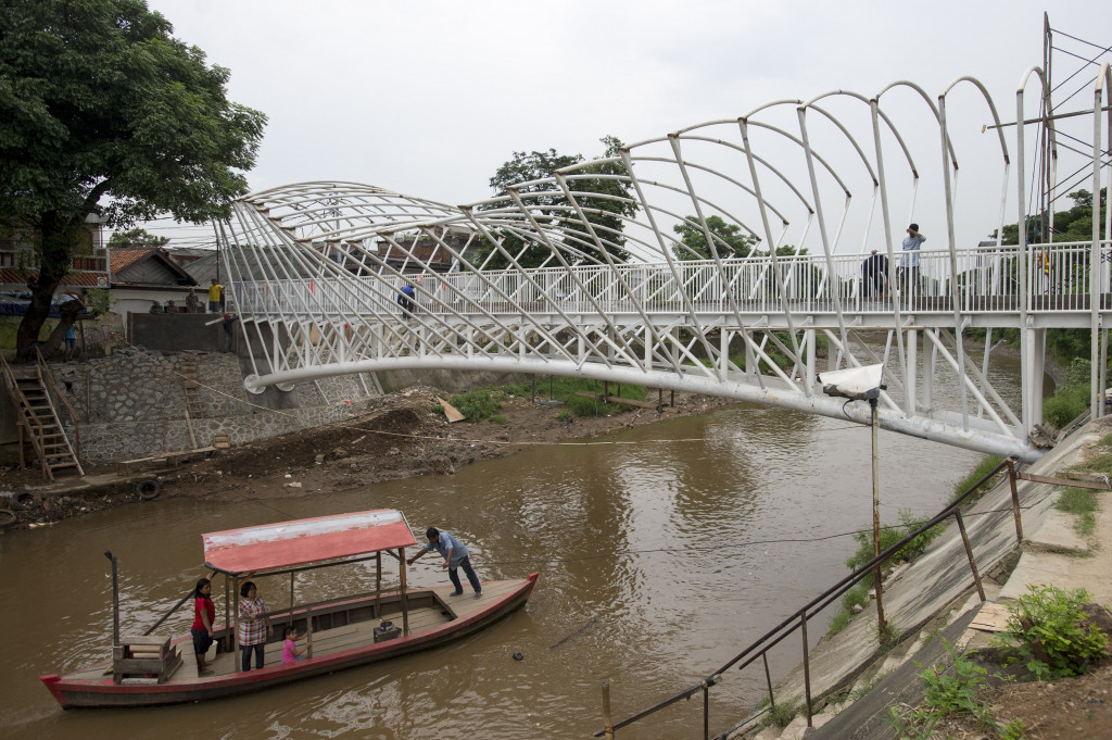 Perahu eretan menyeberangi Sungai Ciliwung di dekat proyek pembangunan JPO di kawasan Manggarai, Jakarta.
