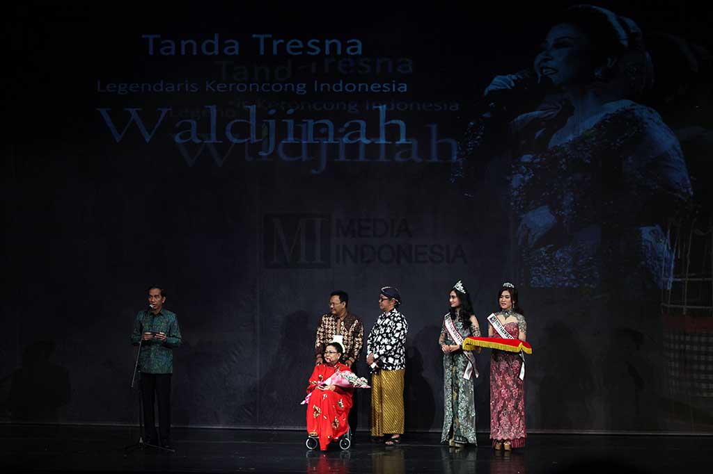 Presiden Jokowi (kiri) menyampaikan ucapan terima kasih atas pengabdian pada seni budaya Indonesia kepada Maestro Keroncong Indonesia Waldjinah (baju merah) pada pertunjukan 'Keroncong Pesona Indonesia Persembahan Untuk Waldjinah' di Taman Ismail Marzuki, Jakarta, Jumat (1/4/2016)