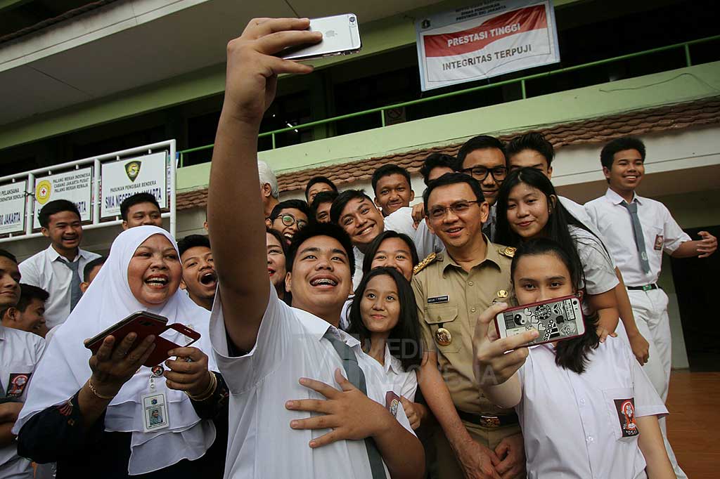 Gubernur DKI Jakarta Basuki Tjahaja Purnama berfoto bersama para siswa-siswi saat meninjau pelaksanaan hari pertama Ujian Nasional Berbasis Komputer (UNBK) di SMA Negeri 30 Jakarta.
