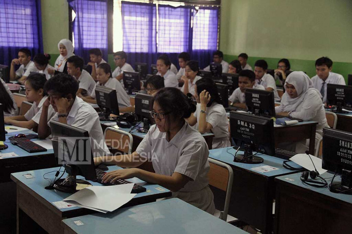 Siswa-siswi mengerjakan soal Ujian Nasional Berbasis Komputer (UNBK) di SMA Negeri 30 Jakarta.