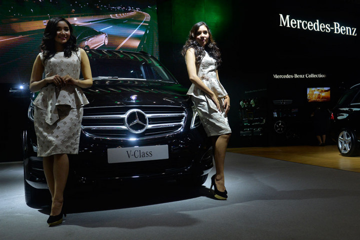 Penjaga stan berdiri di samping mobil Mercedes Benz V Class 