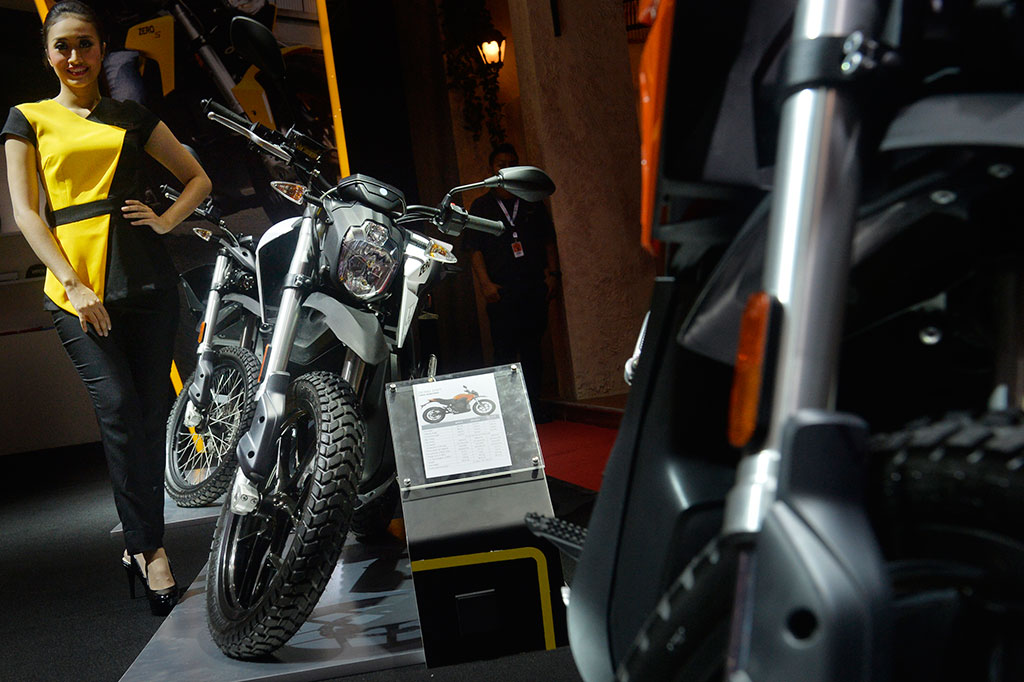 Penjaga stan berdiri di samping motor bertenaga listrik buatan eropa