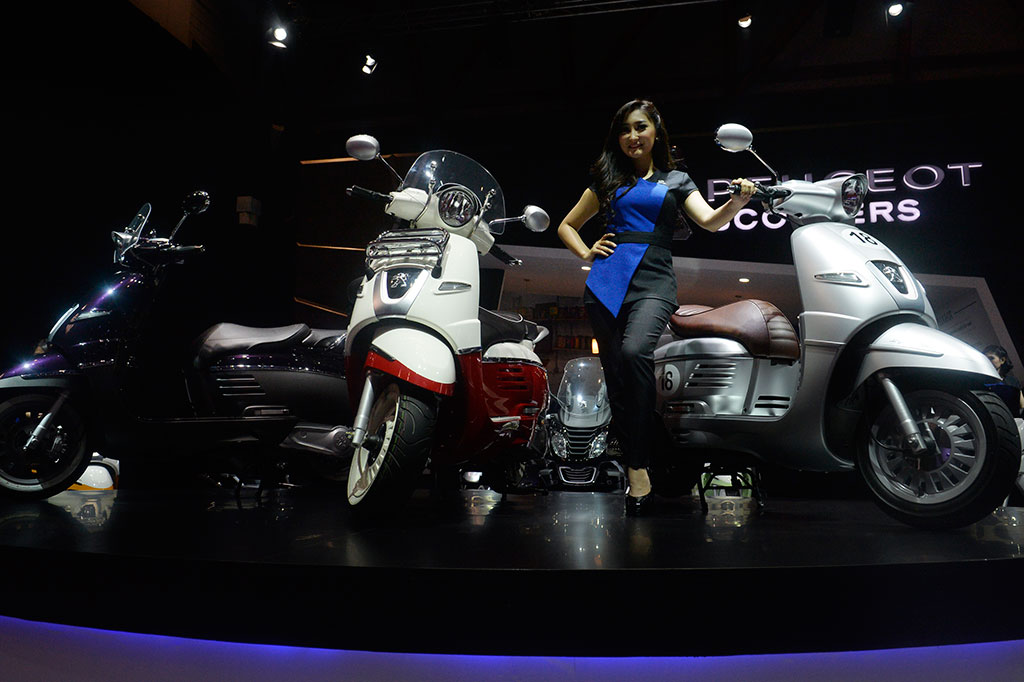  Penjaga stan berdiri di samping motor matic buatan eropa 