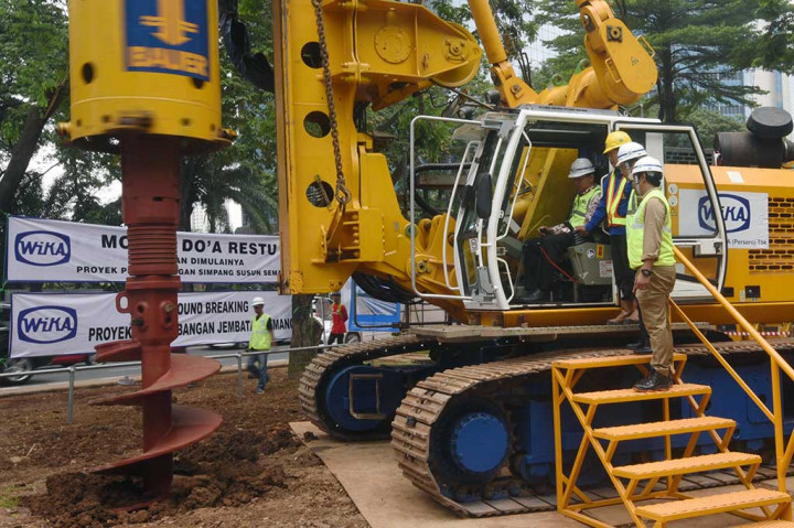 Ahok (duduk) mencoba mengoperasikan mesin bor saat meresmikan proyek jembatan layang simpang susun Semanggi.
