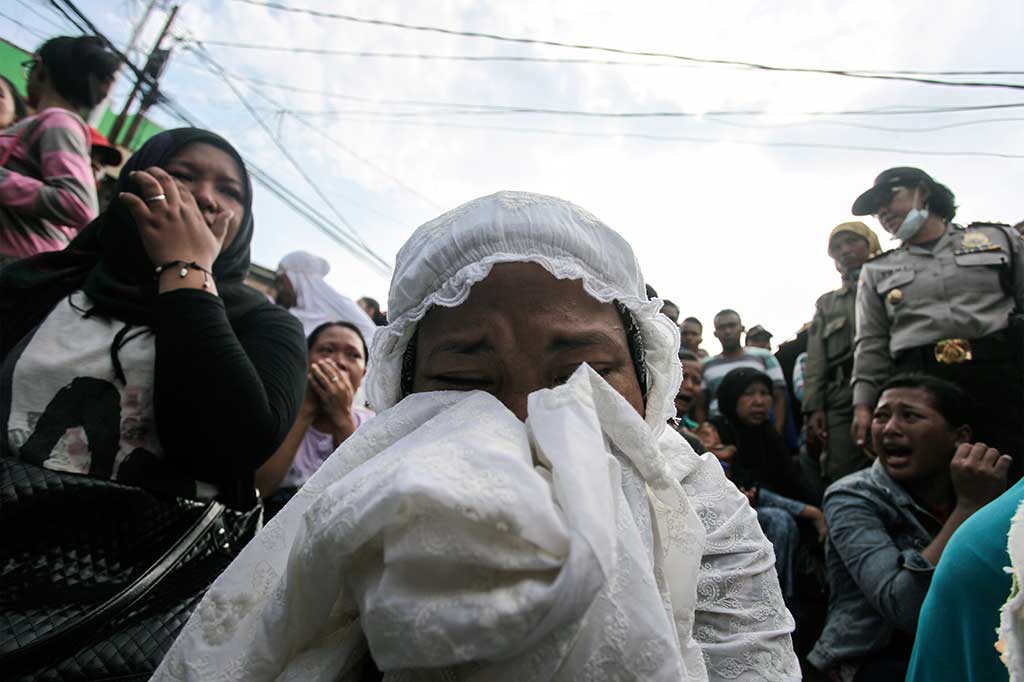 Warga Kampung Luar Batang berdoa saat pemukimannya akan dibongkar oleh petugas.
