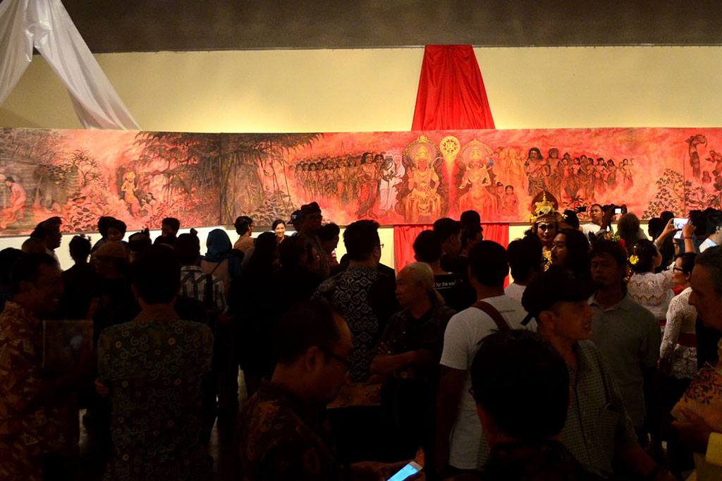 Pengunjung mengamati lukisan karya I Ketut Budiana saat pembukaan pameran lukisan bertajuk 'Prabu Udayana: Wiracita Dalam Rupa'.