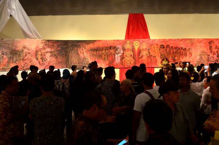 Pengunjung mengamati lukisan karya I Ketut Budiana saat pembukaan pameran lukisan bertajuk 'Prabu Udayana: Wiracita Dalam Rupa'.