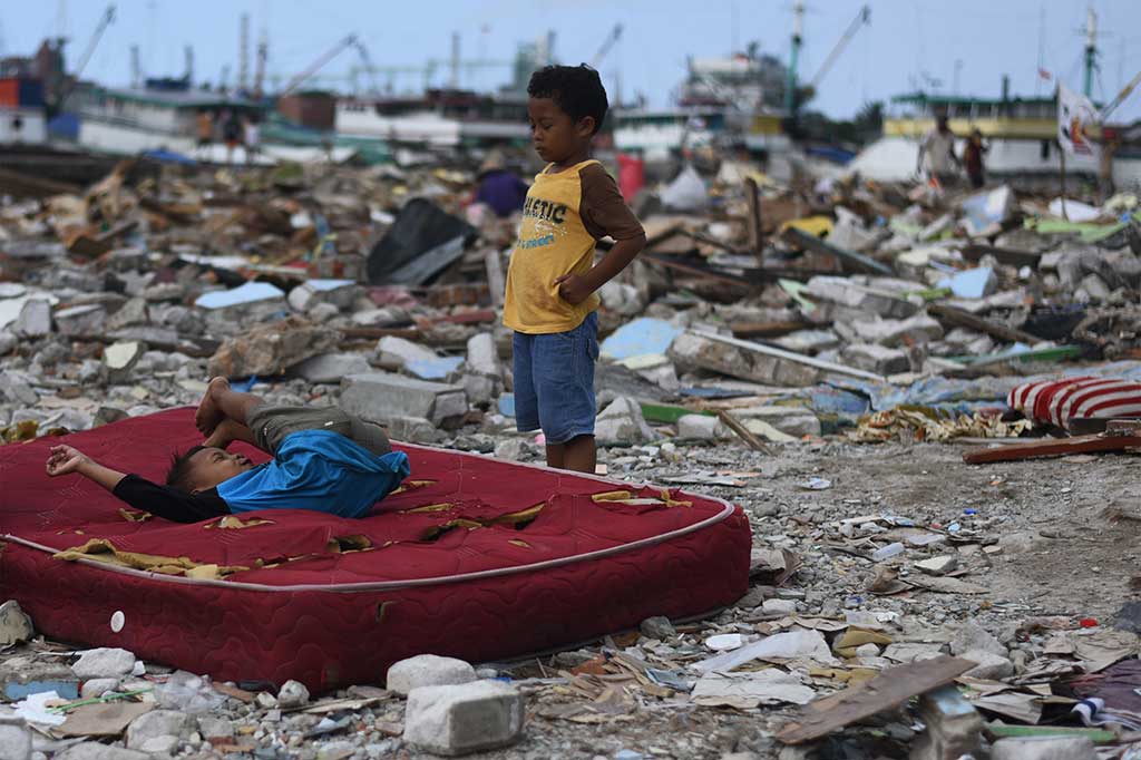Dua orang anak bermain di lokasi penggusuran.