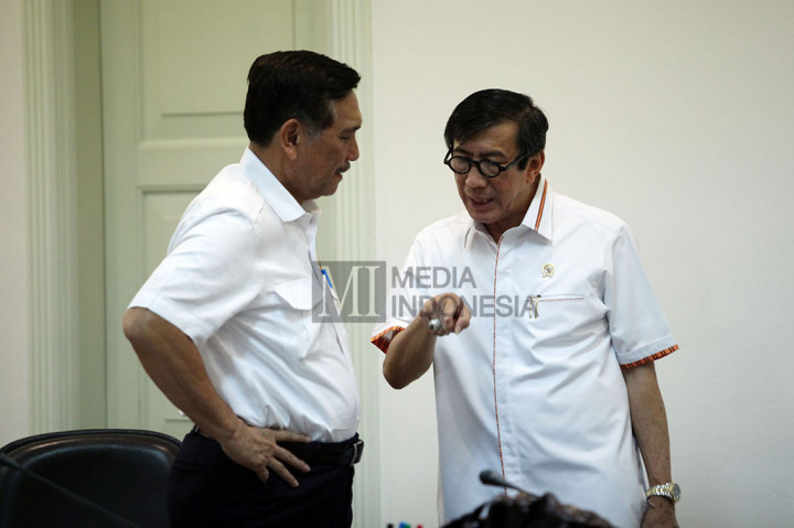 Menko Polhukam Luhut Pandjaitan (kiri) berbincang dengan Menkumham Yasonna Laoly sebelum mengikuti rapat terbatas.