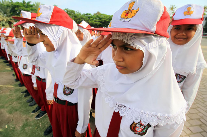 Siswa sekolah dasar mengikuti upacara peringatan Hari Pendidikan Nasional di lapangan Hiraq, Lhokseumawe, Provinsi Aceh, Senin. Peringatan bertema 'Nyalakan Pelita, Terangkan Cita-cita' itu disertai penyerahan penghargaan Menteri Pendidikan dan Kebudayaan kepada 15 sekolah SMP/SMA sederajat sebagai Indek Integritas Penyelenggaran Ujian Nasional di Aceh. ANTARA/Rahmad