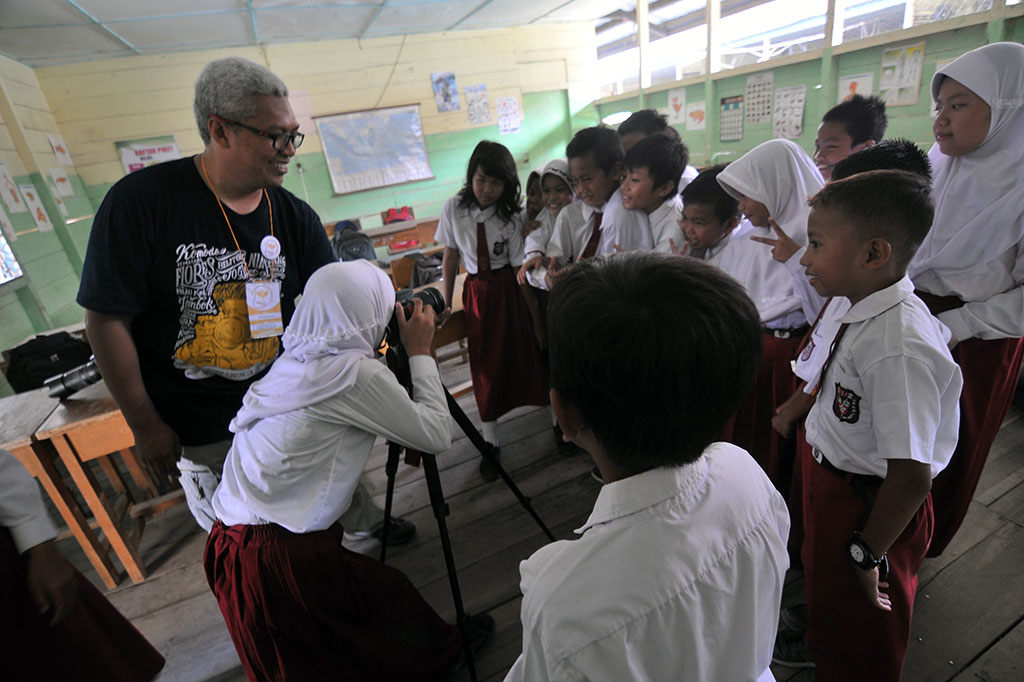 Relawan Kelas Inspirasi Jambi yang juga pegiat fotografi Riko Mappedeceng (kiri) mengajarkan dasar-dasar fotografi kepada pelajar SDN 68 Kota Jambi di Danau Sipin, Jambi, Senin (2/5). Dalam rangka memperingati Hari Pendidikan Nasional, puluhan relawan serentak memberikan pengajaran di 25 SDN pinggiran di daerah itu melalui program Kelas Inspirasi Jambi. ANTARA/Wahdi Septiawan